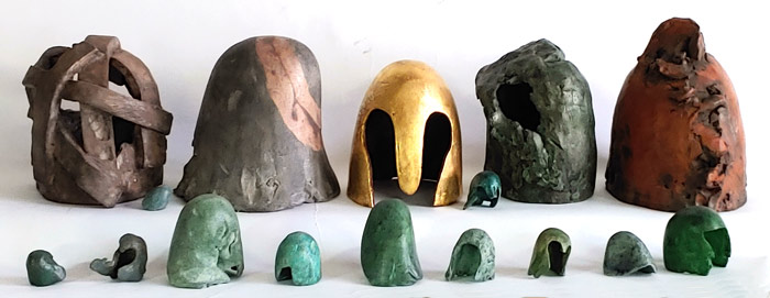A range of sizes of Helmet sculptures, terra-cotta, gold leaf.