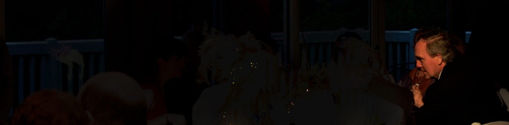 A man and woman are seated at a table, engaged in conversation.